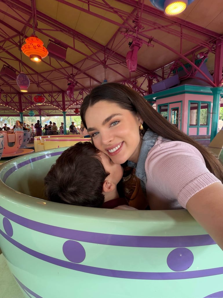 Nadia Ferreira con cabello largo y oscuro abraza a un niño sonriente, en un entorno recreativo colorido y lúdico.