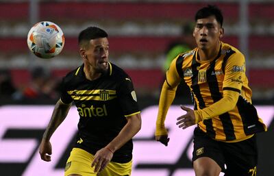 Penarol's forward Marcelo Cabrera (L) and The Strongest's forward Jeyson Chura fight for the ball during the Copa Libertadores round of 16 second leg football match between Bolivia's The Strongest and Uruguay's Peñarol at the Hernando Siles stadium in La Paz on August 21, 2024. (Photo by AIZAR RALDES / AFP)