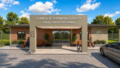 Perro sentado junto a una mujer en un banco, edificio de clínica veterinaria pública de fondo con señalización clara.
