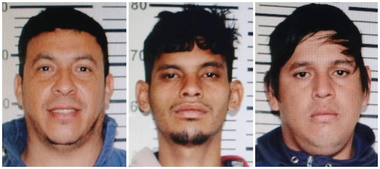 Tres hombres con expresiones serias en fondo gris con marcas de altura para identificación.