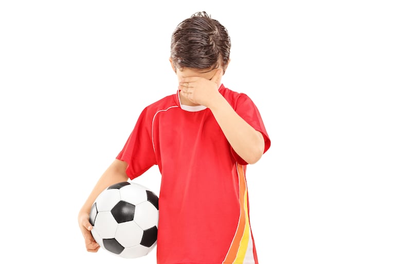 Niño triste tras la derrota en un juego deportivo, imagen ilustrativa.