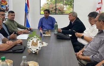 Caballero en camisa azul y Aguilera en verde participan en reunión con autoridades del municipio de las Palmas.