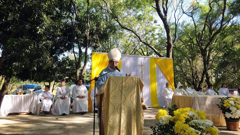 Monseñor Osmar López en vestimenta clerical, dirigiéndose a la audiencia en un ambiente ceremonial con flores y utensilios religiosos.