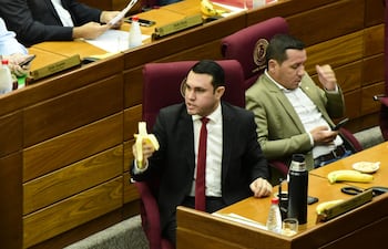 El senador cartista Hernán Rivas comía una banana mientras se votaba su desafuero. A su lado, su colega Javier "Chaqueñito" Vera se distrae con el celular.