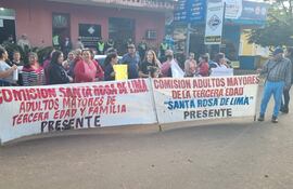 Grupo de adultos mayores con pancartas, expresiones decididas, manifestándose pacíficamente en la calle frente al Ministerio Público.