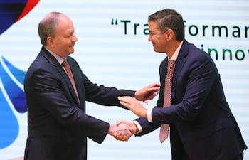 Fotografía de archivo del 21 de octubre de 2025 del exministro de Economía y Finanzas de Paraguay, Carlos Fernández Valdovinos (i), saludando al presidente de Paraguay, Santiago Peña, durante un evento en Asunción (Paraguay). Peña removió este martes a Fernández Valdovinos, en el marco de los cambios que lleva a cabo en el Gobierno tras cumplir la mitad de su mandato de cinco años y cuando el país ha emprendido ajustes fiscales como parte de un plan de "economía de guerra".