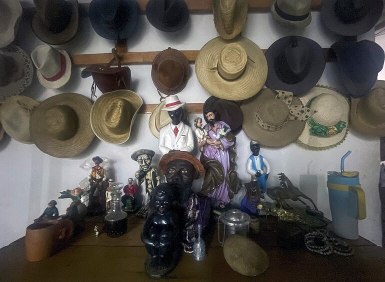 Sombreros y figurillas que representan a juremeros cuelgan en la entrada de una sala donde los practicantes bailan para entrar en estado de trance y conectarse con los espíritus, conocidos como caboclos, en Planaltina, Distrito Federal de Brasil.