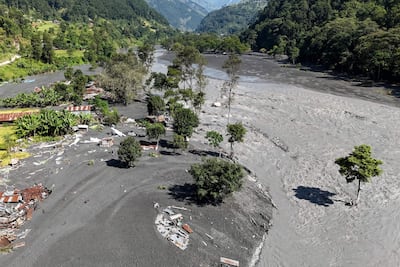 Una vista aérea muestra los restos de viviendas cubiertas de lodo mientras el agua turbia fluye por el río Budhi Gandaki, en el distrito de Gorkha, Nepal, el 14 de octubre de 2026, tras una inundación repentina provocada por un deslizamiento de tierra en seco.