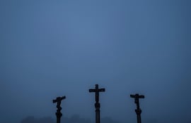 Detalle de tres cruceiros en el entorno de la iglesia de Beade, en la comarca orensana de O Ribeiro bajo una manta de niebla.