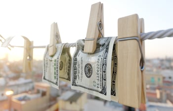 Imagen de referecia de lavado de dinero. Billetes extendidos y atajados con pinzas.