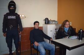 Fredy Antonio Florenciano Brítez, acusado de supuesto homicidio doloso y coacción sexual, junto a la defensora pública Zulma Zárate y bajo custodia policial.