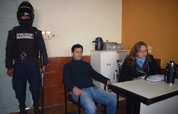 Fredy Antonio Florenciano Brítez, acusado de supuesto homicidio doloso y coacción sexual, junto a la defensora pública Zulma Zárate y bajo custodia policial.