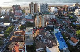 Fotografía aérea que muestra integrantes de los bomberos y grupos de rescate trabajando en la búsqueda de personas entre los escombros del edificio Aparthotel Dubrovnik este miércoles, en el municipio de Villa Gesell, provincia de Buenos Aires (Argentina). La propietaria del hotel derrumbado en la ciudad argentina de Villa Gesell, María Rosa Stefanic, de 52 años, fue hallada muerta entre los escombros, confirmaron este jueves fuentes oficiales.