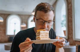 ¿A qué huele la felicidad? Imagen de un hombre oliendo una torta.