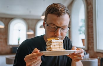 ¿A qué huele la felicidad? Imagen de un hombre oliendo una torta.