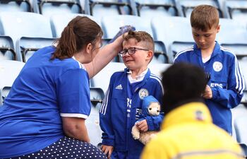 Una madre aficionada del Leicester trata de consolar a su hijo tras consumarse el descenso del equipo, que en el 2016 había logrado el título de la Liga Premier.