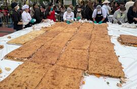 Personas preparan un pan con chicharrón este miércoles, en el distrito de Magdalena del Mar, en Lima (Perú).