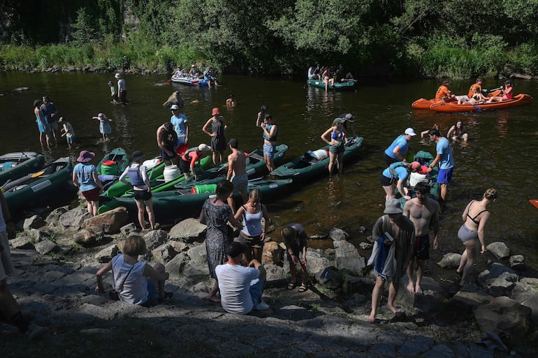 Los turistas salen en botes mientras otros se bañan en el río Vltava en Cesky Krumlov, Bohemia del Sur.