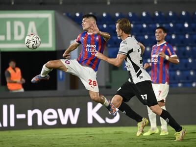 Alexis Fariña intenta un remate forzado ante la atenta mirada de Walter Clar, quien no llega para la marca.