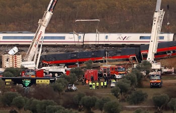 Grúas gigantes son utilizadas para mover los vagones de los trenes siniestrados cerca de Urda, en la provincia española de Toledo.