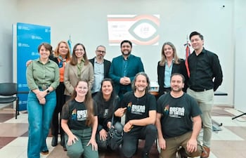 Grupo de diez personas, cinco de pie y cinco en cuclillas, con camisetas de 'OBERÁ EN CORTOS' y fondo institucional.