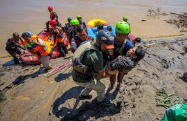 Rescatistas evacúan a un vecino de una localidad afectada por las inundaciones en Bireuen, en la provincia indonesia de Aceh.