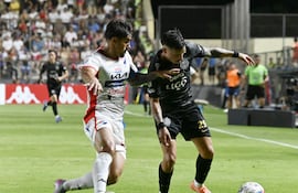 Iván Leguizamón, futbolista de Olimpia, disputa el balón ante Roberto Ramírez, jugador de Nacional, en un partido por la cuarta fecha del torneo Apertura 2026 de la Primera División de Paraguay en el estadio Arsenio Erico, en Asunción, paraguay.