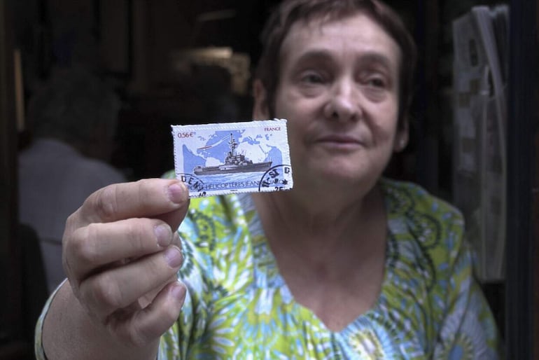Catherine, quien regenta el local 'Filatelia Marigny', muestra un sello en venta. Panoramas, París.