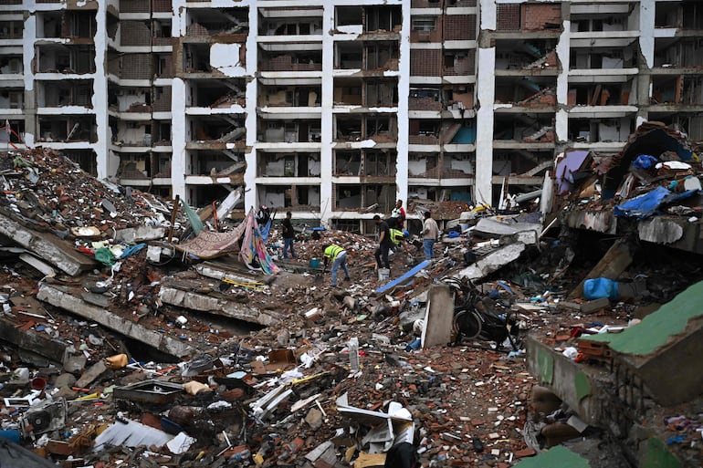 Trabajadores de rescate buscan entre los escombros de edificios derrumbados en Caraballeda, estado La Guaira, Venezuela, el 11 de julio de 2026, después de los dos terremotos que golpearon la región. El presidente de la Asamblea Nacional, Jorge Rodríguez, dijo el 11 de julio que el número de muertos ha superado los 4.300.