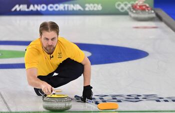 El sueco Rasmus Wranaa lanza la piedra en la ronda de dobles mixtos de curling entre Estonia y Suecia durante los Juegos Olímpicos de Invierno Milano Cortina 2026 en el Estadio Olímpico de Curling de Cortina d'Ampezzo el 5 de febrero de 2026.