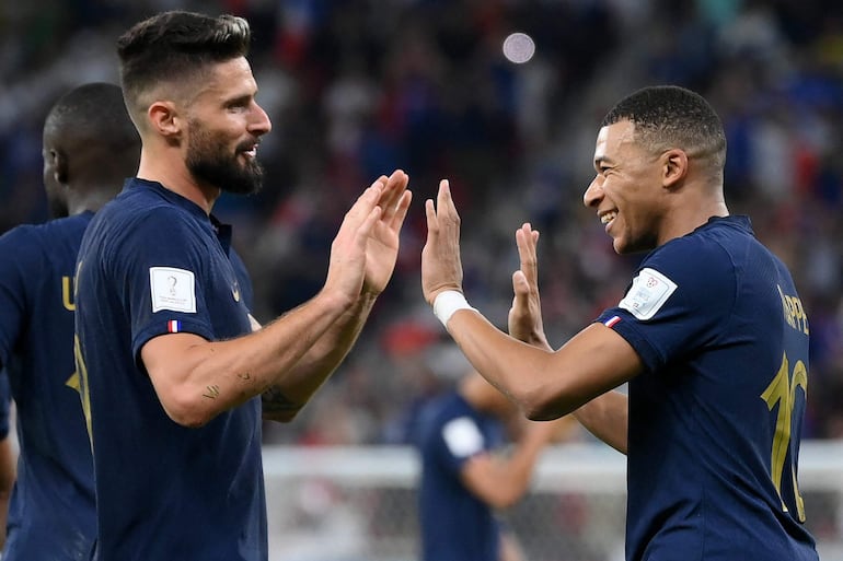 El delantero de Francia, Kylian Mbappé (D), celebra su anotación con Olivier Giroud, durante el partido de fútbol de los octavos de final de la Copa del Mundo de Qatar 2022.