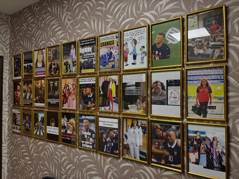 Pared decorada con marcos dorados que muestran memes y carteles sobre fútbol, sin personas visibles en la imagen.