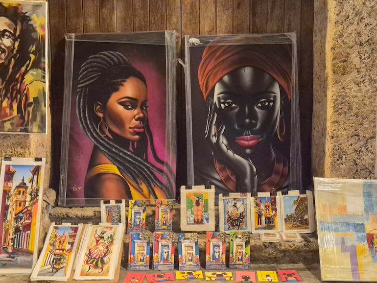 Galería de arte con retratos de mujeres afrocolombianas y pinturas culturales en un ambiente acogedor.