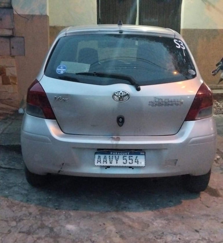 Vehículo sedan plateado modelo Toyota Vitz estacionado, matrícula AAVY 554, sin personas visibles en escena.