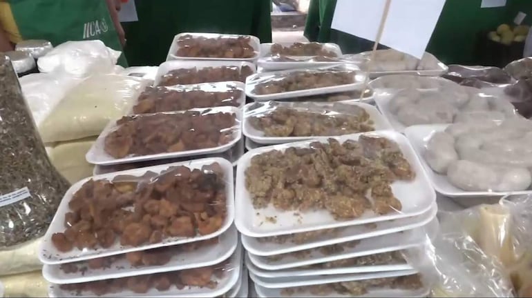 Platos de chicharõ en ferias familiares, con colores marrones y beige, en mesas organizadas, rodeados de visitantes.