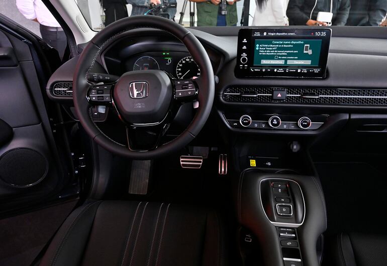 Interior de un Honda HFT mostrando el volante y la pantalla digital, sin personas presentes.