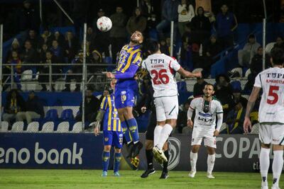 El delantero del Sportivo Luqueño, Marcelo Pérez, en el duelo aéreo con el zaguero de Atlético Tembetary, Pablo Adorno.