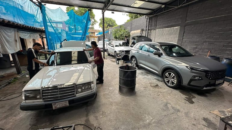 Empleados realizando cambio de parabrisas y arreglo de chaperia.