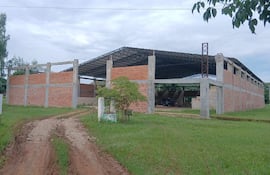 Construcción inacabada de la plaza deportiva San Rafael con muros de ladrillo y estructura metálica.