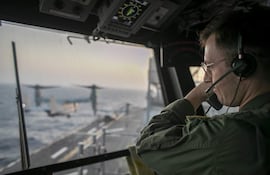 Un oficial naval a bordo del USS Tripoli (LHA 7) supervisa las operaciones de vuelo desde la torre de control mientras el buque de asalto anfibio navega en el mar Arábigo. Dos buques de guerra de EE.UU. lograron atravesar el estrecho de Ormuz e ingresar al golfo Pérsico este lunes, pese a un ataque coordinado con drones, misiles y pequeñas embarcaciones, atribuido a Irán.
