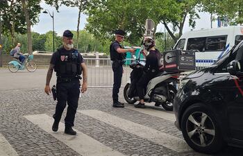 Policías paran el tráfico y a peatones en las inmediaciones del río Sena en París (Francia), durante el primer día de implementación del dispositivo de seguridad Pass Jeux, que limita la circulación en zonas emblemáticas de la capital gala, con motivo de la celebración de los Juegos Olímpicos y Paralímpicos de París 2024.