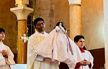 El párroco de la Basílica Menor Nuestra Señora del Pilar, Rvdo. José Dolores Echeverría Valdez, sostiene la imagen de la Virgen Nuestra Señora del Pilar.