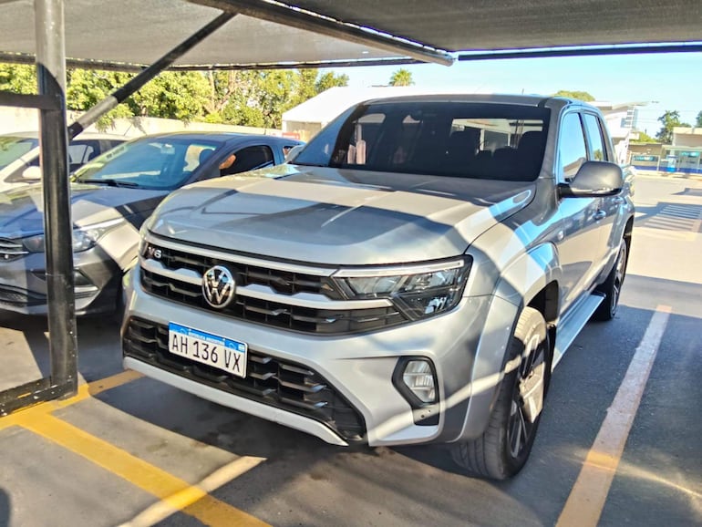 Estacionamiento con camioneta Volkswagen plateada y dos vehículos más en un área techada sin presencia de personas.