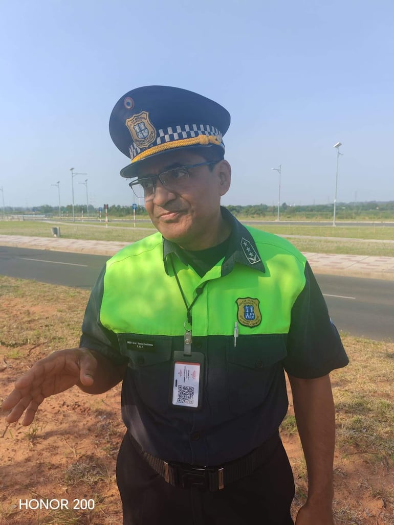 Inspector Daniel Cárdenas con uniforme de policía, gesticulando en un entorno al aire libre, bajo un día soleado.