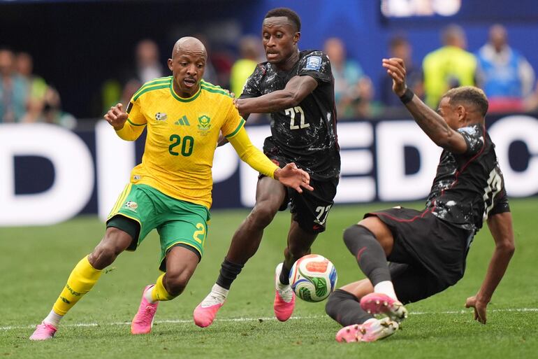 Khuliso Mudau (I) de Sudáfrica en acción contra Richie Laryea (C) de Canadá durante el partido de los dieciseisavos de final de la Copa Mundial de la FIFA 2026 entre Sudáfrica y Canadá, en Los Ángeles, EE. UU..