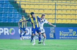 El delantero del Sportivo Luqueño, Sergio Díaz intenta llevarse el esférico ante la marca del volante argentino Valentín Larralde.