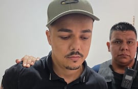 Patrick Fernandes de Oliveira (33), custodiado por un agente policial tras su detención.