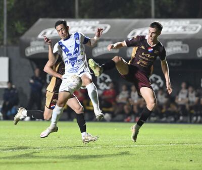 El capitán de Ameliano, Ëdgar Zaracho no le da tregua por la pelota al nacionalófilo Juan Fernando Alfaro, en Trinidad.