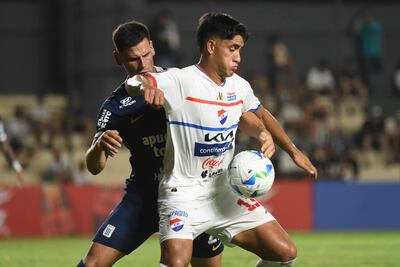 TOPSHOT - Alianza Lima's Argentine defender #22 Guillermo Enrique (L) and Nacional's midfielder #13 Leandro Meza fight for the ball during the Copa Libertadores qualification first round first leg football match between Paraguay's Nacional and Peru's Alianza Lima at the Arsenio Erico stadium in Asuncion, on February 5, 2025. (Photo by DANIEL DUARTE / AFP)