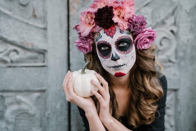 Con su característico tocado floral y maquillaje de calavera, la Catrina sostiene una pequeña calabaza: una imagen que sintetiza la hibridación cultural entre la sátira original de José Guadalupe Posada y la influencia del imaginario anglosajón. Foto: Julia Volk (Pexels).